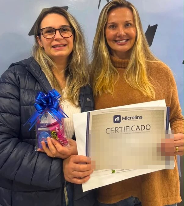 Aluna recebendo certificado de conclusão de curso na Microlins Nova Friburgo